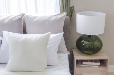 modern lamba ile modern beyaz yatak üzerinde beyaz yastıklar