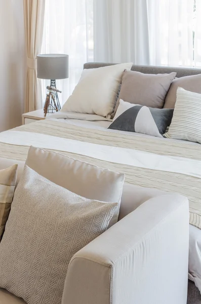 Современная спальня с подушками на кровати — стоковое фото
