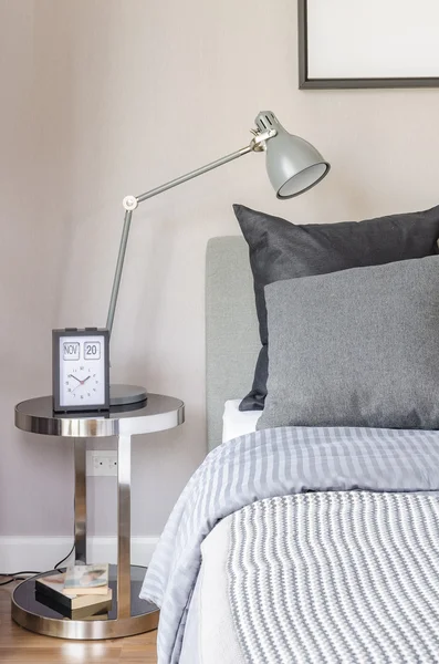Modern grey lamp with alarm clock on side table in bedroom — Stock Photo, Image