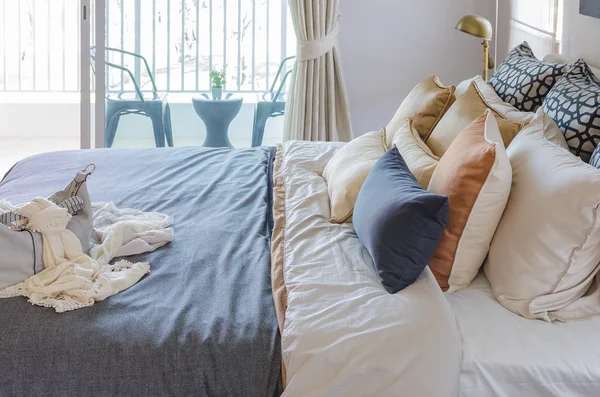 Cuscini su letto moderno con coperta grigia — Foto Stock