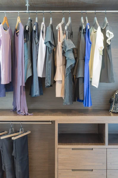 Женская одежда висит на перилах в деревянном шкафу — стоковое фото