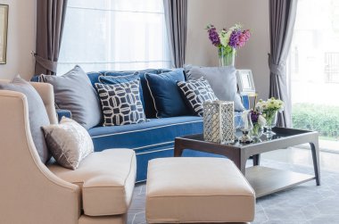 yastıklar ve liv halıda ahşap masa ile klasik mavi koltuk