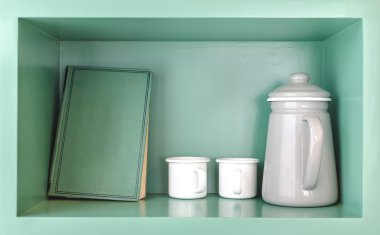 eski yeşil kitap, beyaz çay Kupası ve gri sürahi