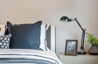 siyah ve beyaz yastık ve battaniye var üzerinde siyah lambalı ta yatak