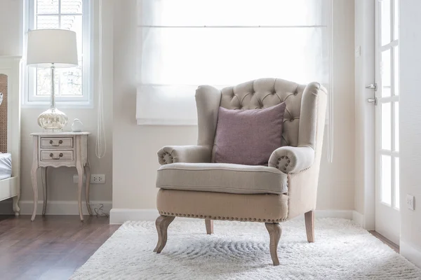 classic chair on carpet with pillow