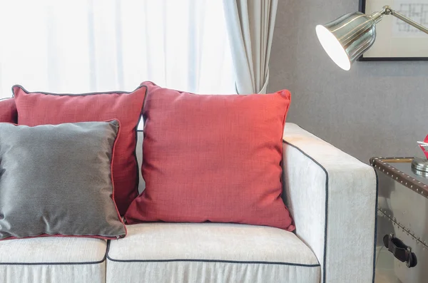 Almohadas rojas y grises en sofá de lujo en la sala de estar — Foto de Stock