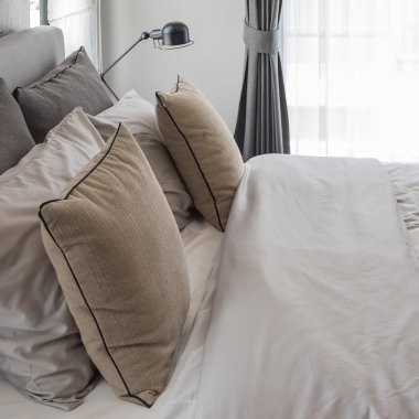 yatakta siyah lambalı kahverengi yastıklar