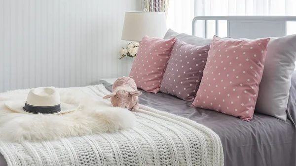 Rosa kuddar med rosa docka på vit trä säng och klassiska hatt — Stockfoto