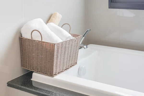 Белое полотенце в корзине на ванной — стоковое фото