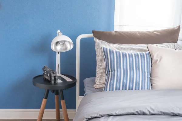 Einzelnes weißes Bett mit weißer Lampe und blauer Wand — Stockfoto