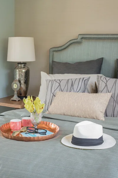 Hut und Tablett mit Glasvasenblume auf dem Bett — Stockfoto