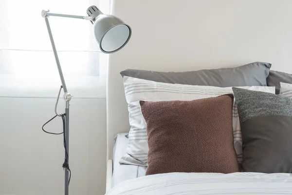 Moderní šedý lampa v moderní ložnice s hnědý polštář — Stock fotografie