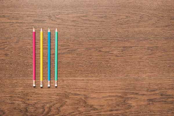 Ahşap arka plan üzerinde çok renkli kalemler — Stok fotoğraf