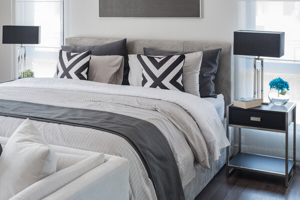 современная спальня с белой кроватью и черной лампой
 