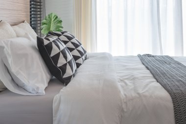 modern yatak odasında yatakta siyah beyaz yastıklar