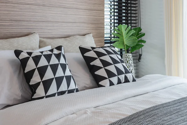 Black and white pillows on bed in modern bedroom — Stock Photo, Image