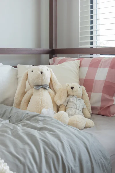 Panenky a hračky na posteli v ložnici dětský — Stock fotografie