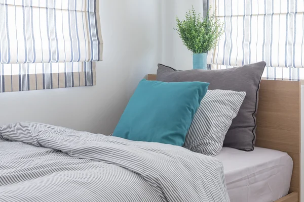 Cama de madeira única com travesseiros e vaso de planta — Fotografia de Stock