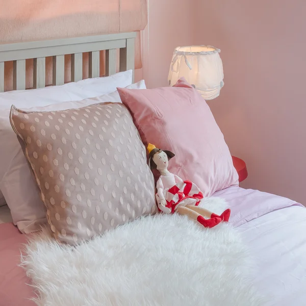 Kızın yatak odasında yatakta bebek ile pembe renk tonu — Stok fotoğraf