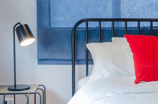 Rotes Kissen und weißes Kissen und Decke auf schwarzem Bett — Stockfoto