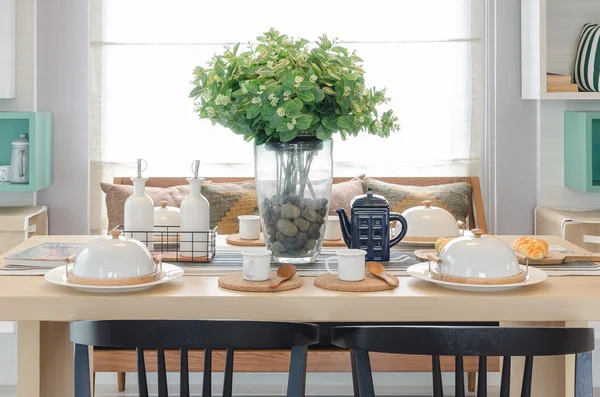 Jarrón de cristal de la planta en mesa de comedor de madera con silla negra —  Fotos de Stock