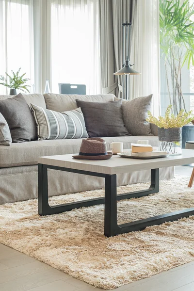 Серый диван и подушки со шляпой на деревянном столе — стоковое фото