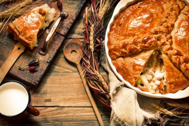 Sebzeli etli turta, ahşap bir tahtanın üzerinde kırsal tarzda altın kabuklu.