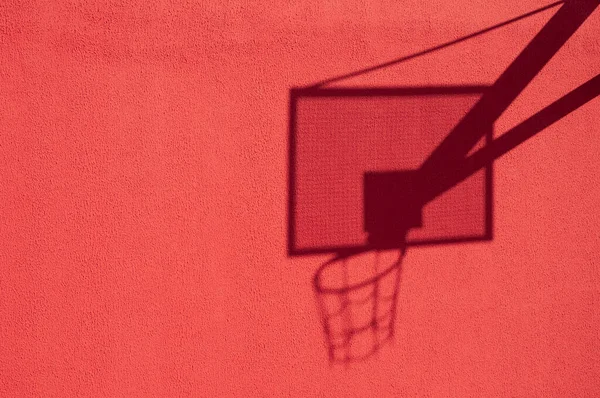 basketball hoop shadow on the red wall
