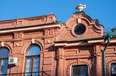 Yuvarlak pencereli eski bir kırmızı tuğla ev.