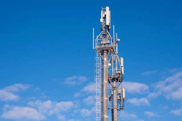 Telekomünikasyon kulesi Mavi Gökyüzü ve Beyaz Bulutlar Arkaplanı. Mavi Gökteki Anten.