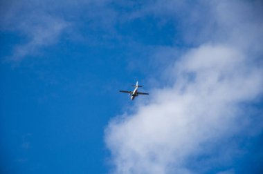 Mavi gökyüzünde uçak ve güneş doğarken bulut