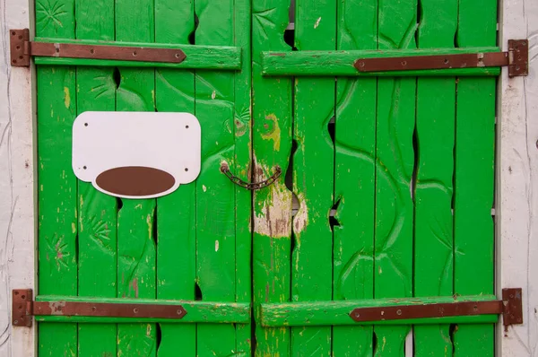 Vintage green wooden gate at the entrance with signage