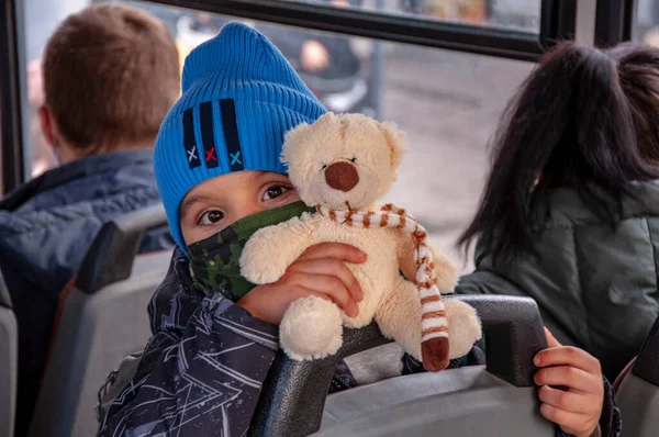 Egy fiú védőruhában, puha játékmedvével a kezében. — Stock Fotó