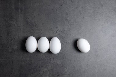 Siyah arka planda beyaz, çiğ, boyanmamış yumurtalar.