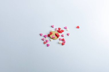Altın para ve bir sürü küçük kırmızı, pembe ve beyaz kalp
