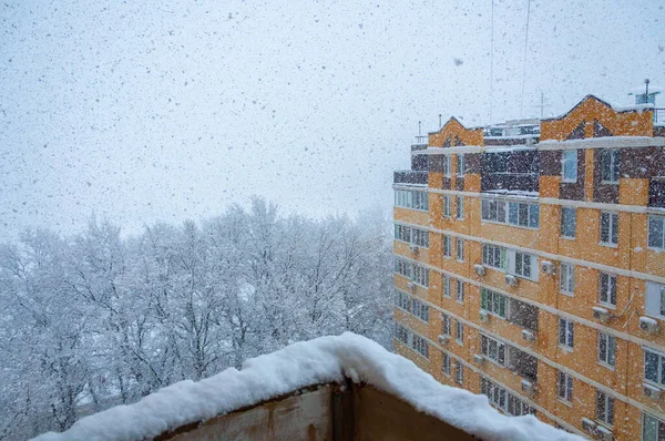 有黄色房子的冬季城市。城里的降雪. — 图库照片