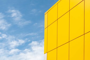 Mavi gökyüzü, bulutlar, binanın ön cephesi.