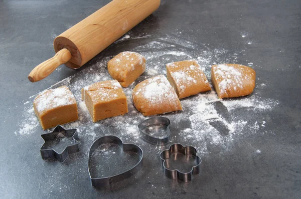 Wooden Rolling pin on floured kitchen worktop. Making shortbread cookies, pastry equipment rolling pin cookie cutters