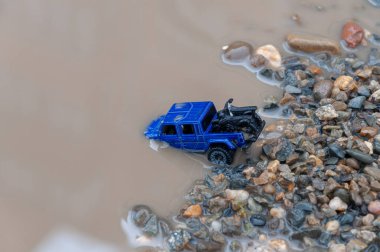 Araba nehri geçer. Araba sel sularına gömülmüş. Tufan Sigortası konsepti. Derin sularda araba sürerken