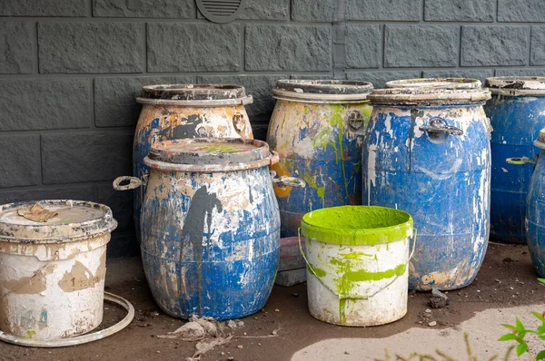 Resíduos industriais, barris de plástico de tinta. Vista de ângulo alto de líquidos em recipientes contra a parede. — Fotografia de Stock