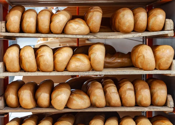 Un montón de pan fresco y crujiente. Estantes llenos de pan de oro fresco. Pan recién horneado se encuentra en el estante para la venta —  Fotos de Stock