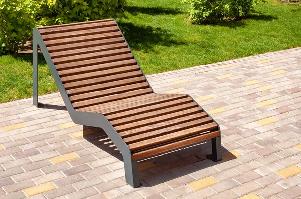 Pohodlná moderní dřevěná lavička. Zlepšení města, urbanismus, veřejné prostory. hnědá dřevěná lavice venkovní nábytek detail — Stock fotografie