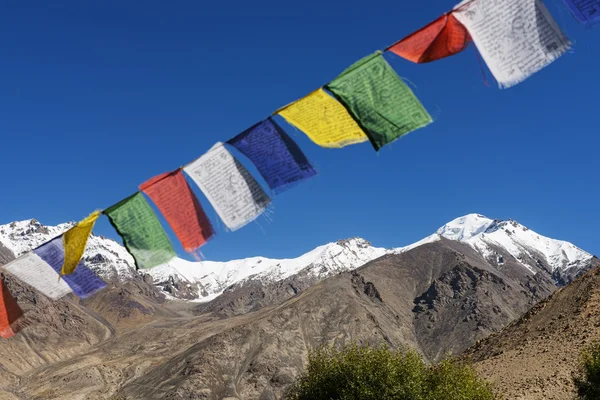 Snow mountain range and tibetan prayer flags in the village — Stock Photo, Image