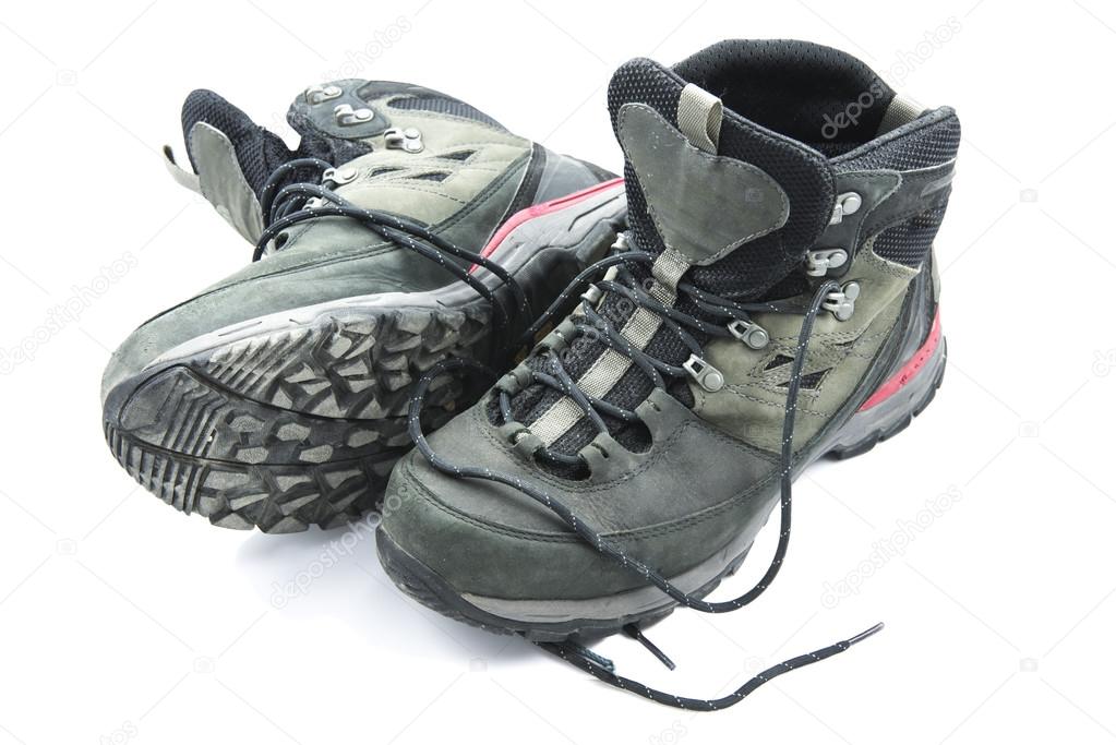 Pair of dirty grey hiking boots isolated on white background.
