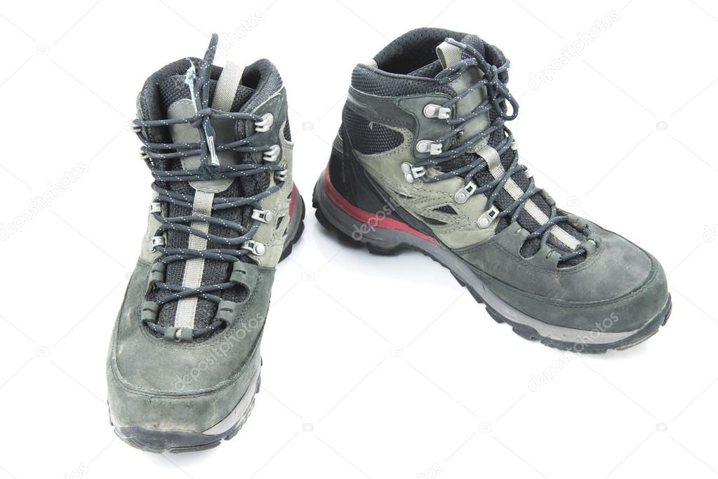 Pair of dirty grey hiking boots isolated on white background.
