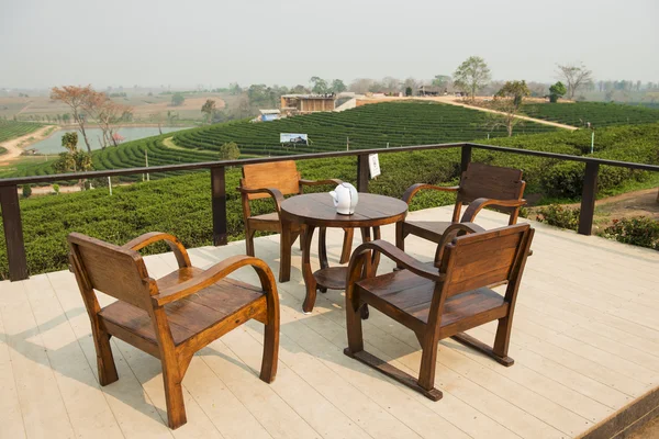 Wooden table tea and tea plantation background at Choui Fong ,Chiangrai Thailand. — Stock Photo, Image