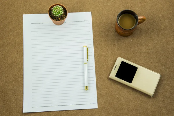 Λευκό χαρτί με το στυλό έξυπνο τηλέφωνο και φλιτζάνι καφέ στο ξύλινο τραπέζι, επιχειρηματική ιδέα — Φωτογραφία Αρχείου