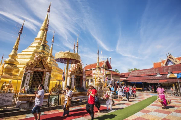 Buddhist people praying and walking around a golden pagoda. — Stock Photo, Image