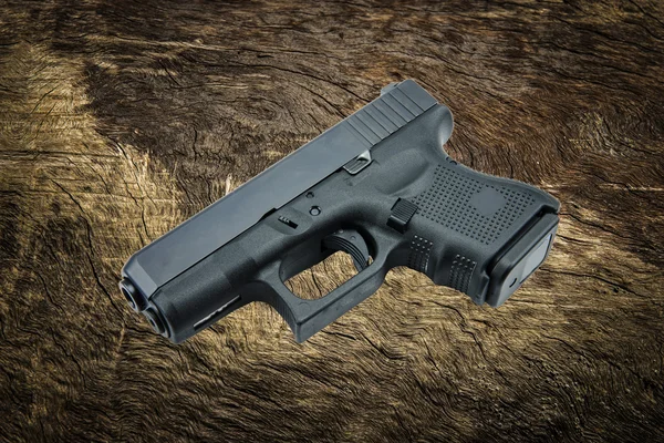 kabuk ağaç arka plan üzerinde tabanca tabanca otomatik 9 mm..