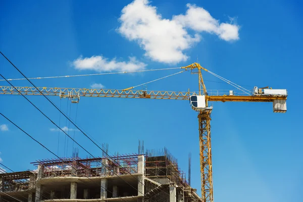 Hospital building under construction with cranes against a blue sky. Royalty Free Stock Photos